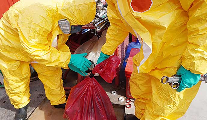 Professional worker cleaning biohazard waste