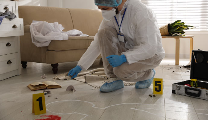 Person in protective gear cleaning crime scene