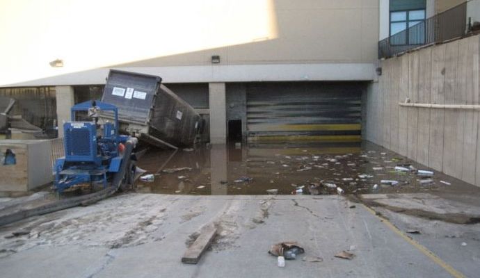 Flooded commercial loading dock with damaged truck and debris Flooded commercial loading dock with damaged truck and debris