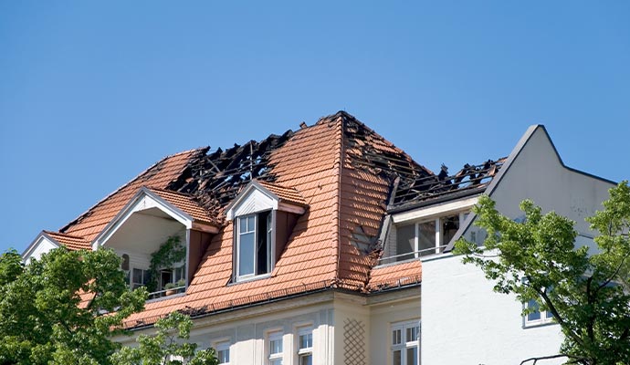 Fire-damaged house roof undergoing repair