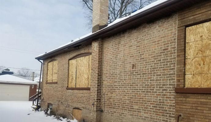 boarded-up windows A house with boarded-up windows